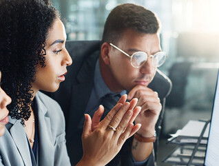 IT team looks at charts on monitor