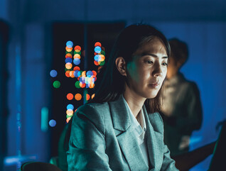 IT specialist working on a laptop in low lighting