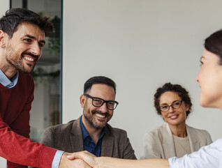 Colleagues shaking hands in an office business meeting