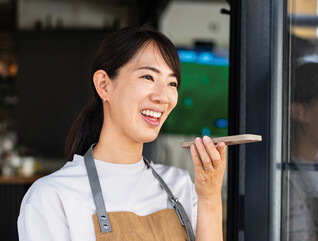 Woman uses phone voice command in cafe