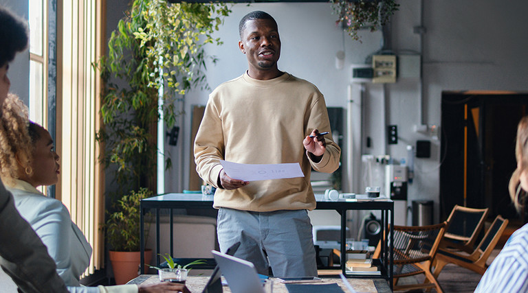 Man talking to 2 people from notes