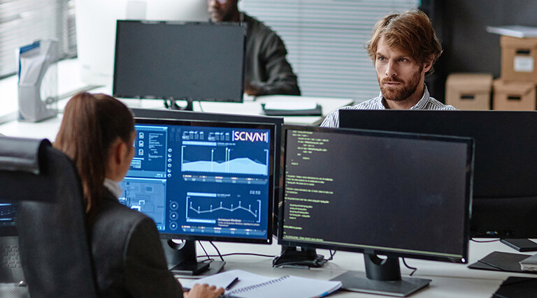 Young IT Developers Working with Multiple Computers