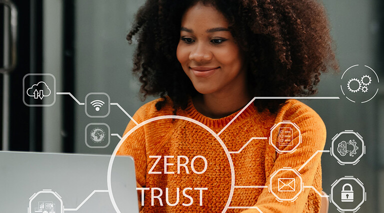 Person using computer and tablet with zero trust icon