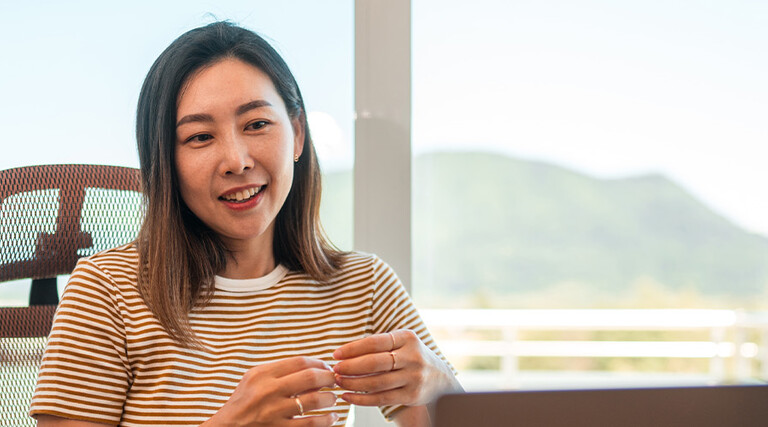 A woman works from home using AI and a laptop