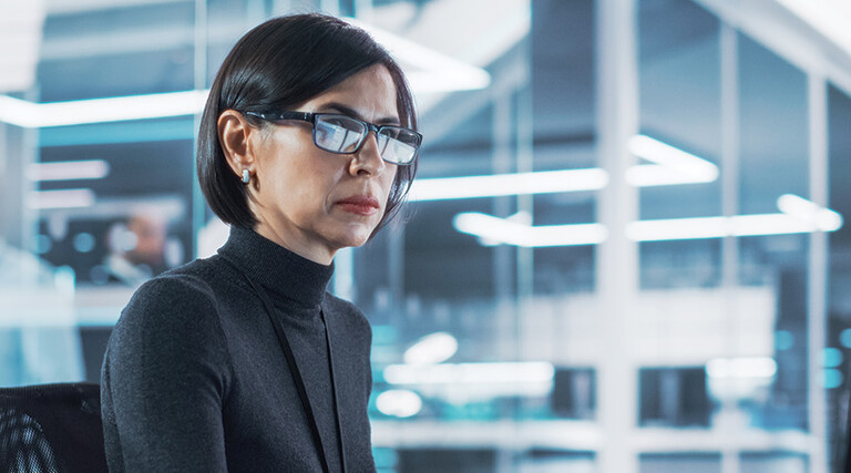 woman looks at computer monitor in office
