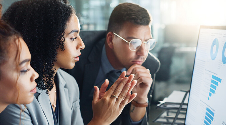 IT team looks at charts on monitor