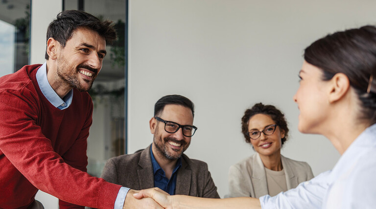 Colleagues shaking hands in an office business meeting