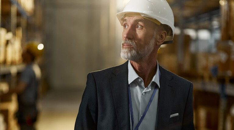 Man in hardhat looking in warehouse