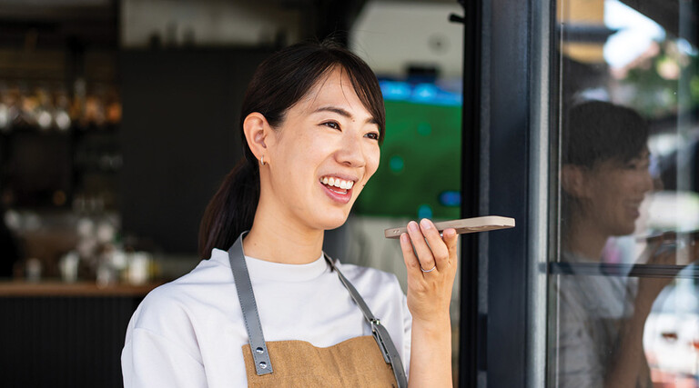 Woman uses phone voice command in cafe