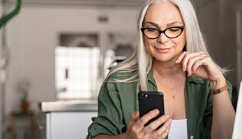 woman with iphone and mac thinking about user experience