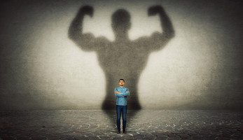 man in bright light with harms up