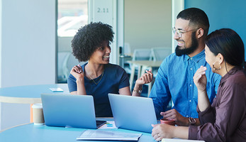 Young business people laughing during a casual meeting in an office