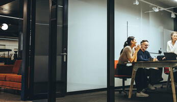 A group of employees gather in a meeting room