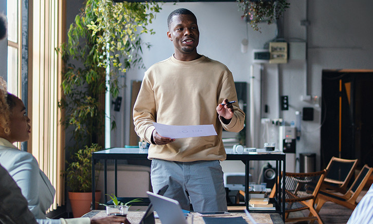 Man talking to 2 people from notes