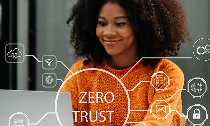 Person using computer and tablet with zero trust icon