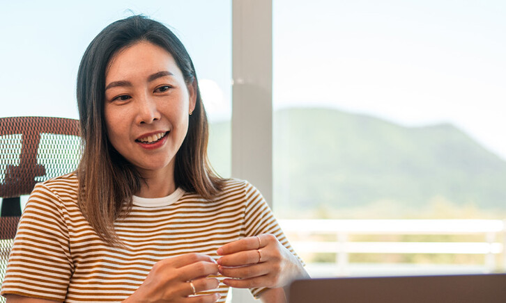 A woman works from home using AI and a laptop
