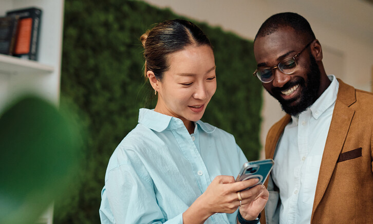 IT leaders holding an android phone in workspace