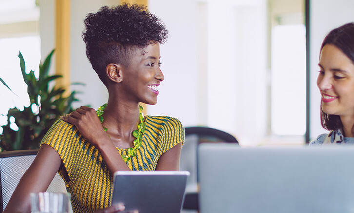small business owners smile around computer