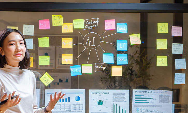 Biz Woman talking at a board with AI & charts