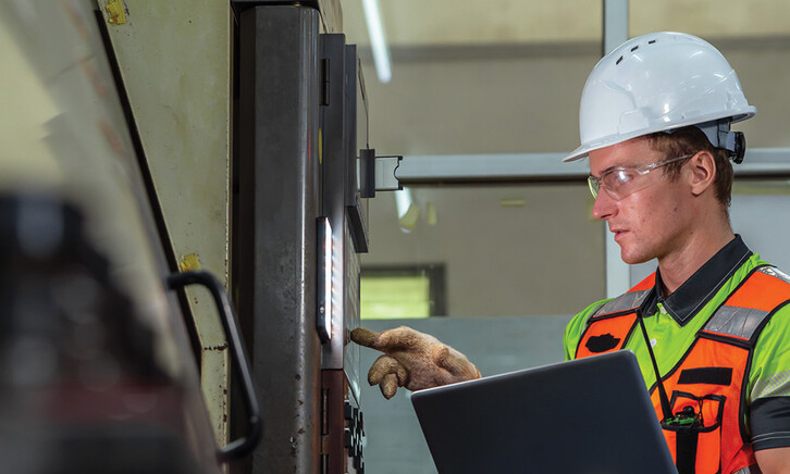 Worker checking a machine in a warehouse