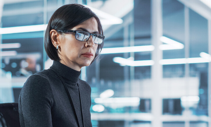 woman looks at computer monitor in office