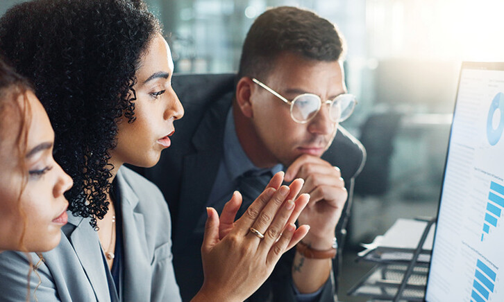 IT team looks at charts on monitor