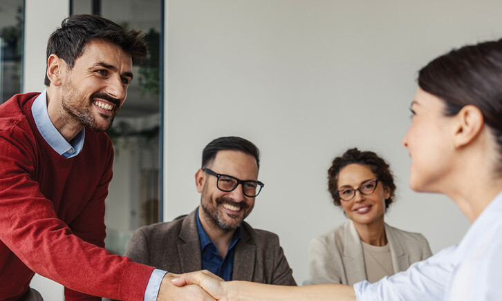 Colleagues shaking hands in an office business meeting