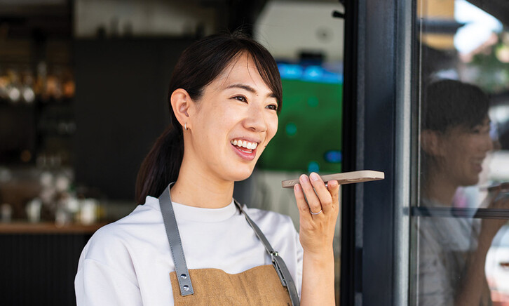 Woman uses phone voice command in cafe