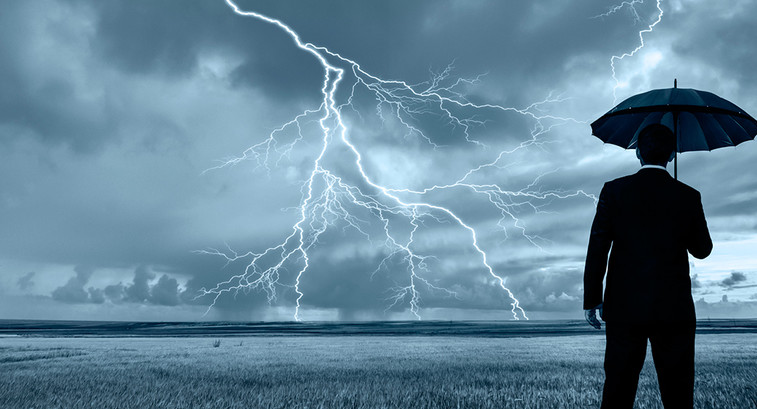 Man with umbrella and lightning on the horizon 