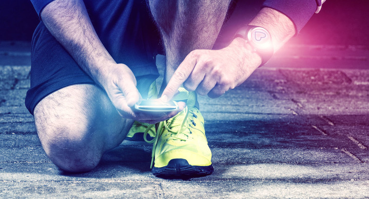 Runner uses mobile phone and smart watch with pulse tracking