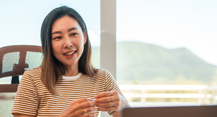 A woman works from home using AI and a laptop