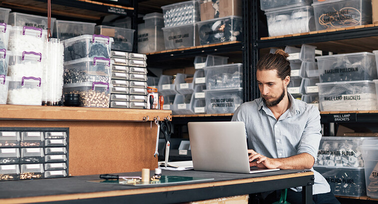 small business owner does inventory on his laptop