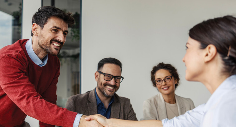 Colleagues shaking hands in an office business meeting