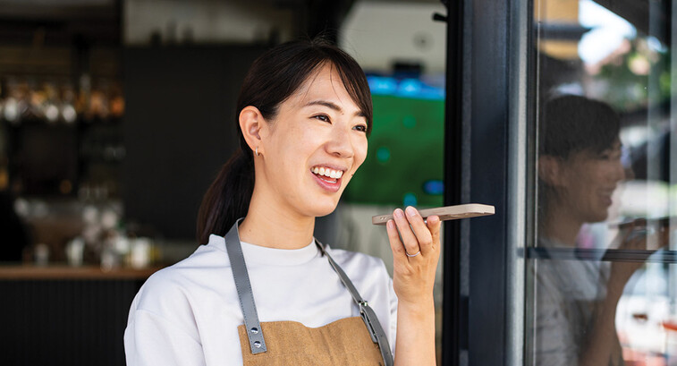 Woman uses phone voice command in cafe