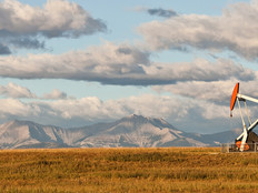 Remote oil well in Alberta, Canada, with mountains in the background 