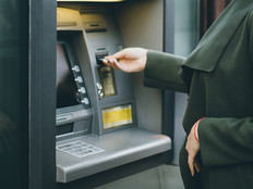 Woman in a green coat using an ATM 