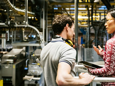 Male and female engineer using technology in a manufacturing plant 