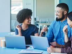 Young business people laughing during a casual meeting in an office