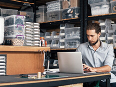 small business owner does inventory on his laptop