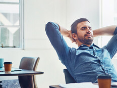 An employee leans back at his desk
