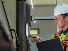 Worker checking a machine in a warehouse