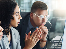 IT team looks at charts on monitor