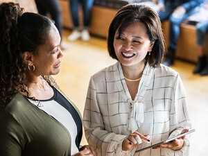 Two colleagues talking and using a digital tablet at work