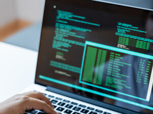 Person coding on laptop