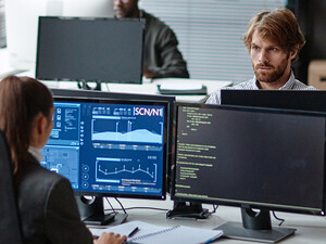 Young IT Developers Working with Multiple Computers