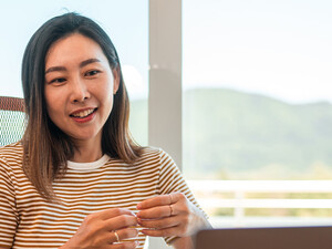 A woman works from home using AI and a laptop