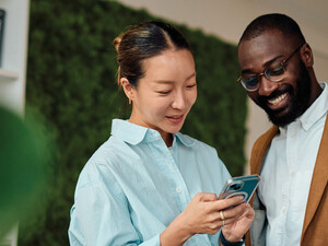 IT leaders holding an android phone in workspace