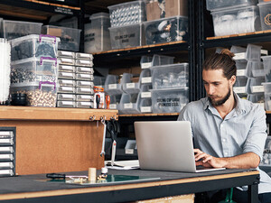 small business owner does inventory on his laptop