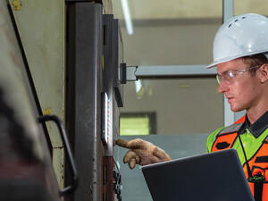 Worker checking a machine in a warehouse