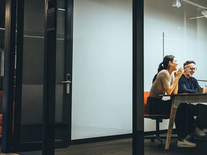 A group of employees gather in a meeting room